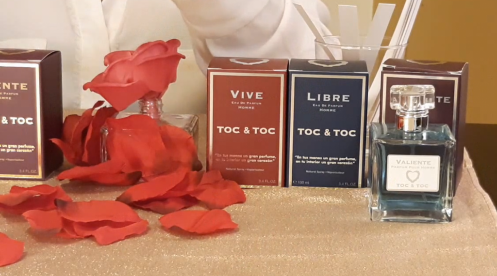 Frascos y estuches de perfumes TOC & TOC junto a pétalos de rosa